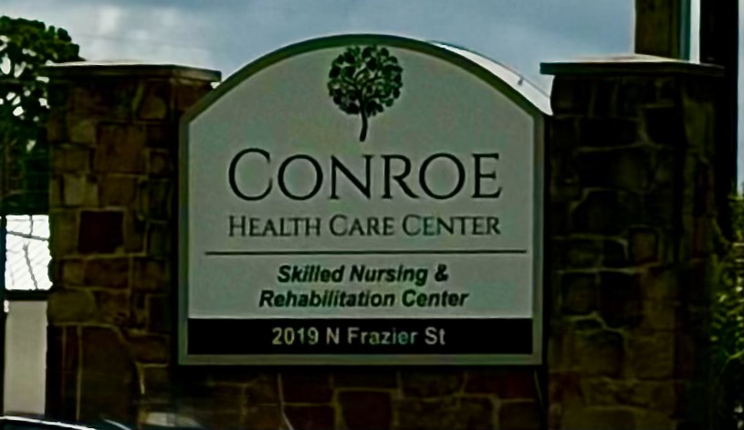 Conroe Health Care Center marquee sign with P91 Roofing vehicles on site