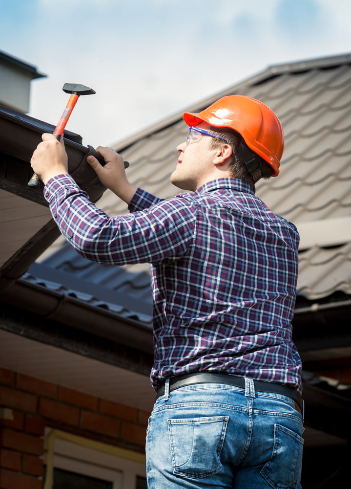 Portrait of carpenter at work repairing roof